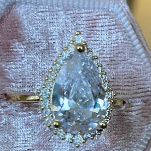 Teardrop white stone w/ white stone halo.